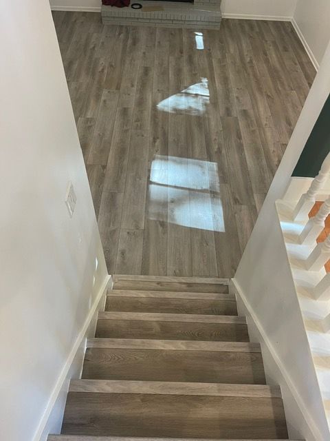 A set of stairs leading up to a living room with a wooden floor.