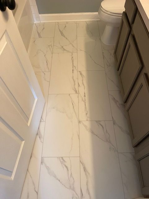 A bathroom with white tile floors and a toilet.