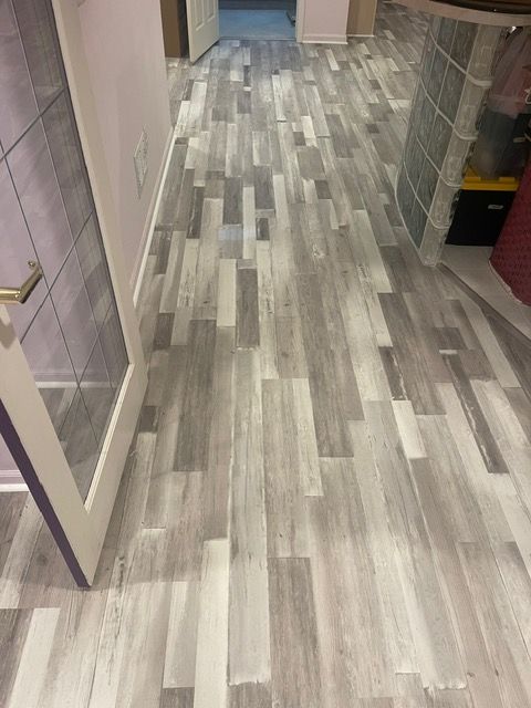 A hallway with a wooden floor and a door.