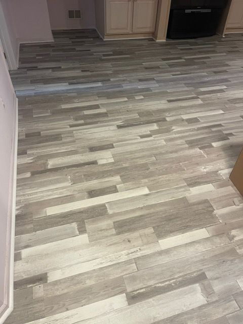 A close up of a wooden floor in a kitchen.