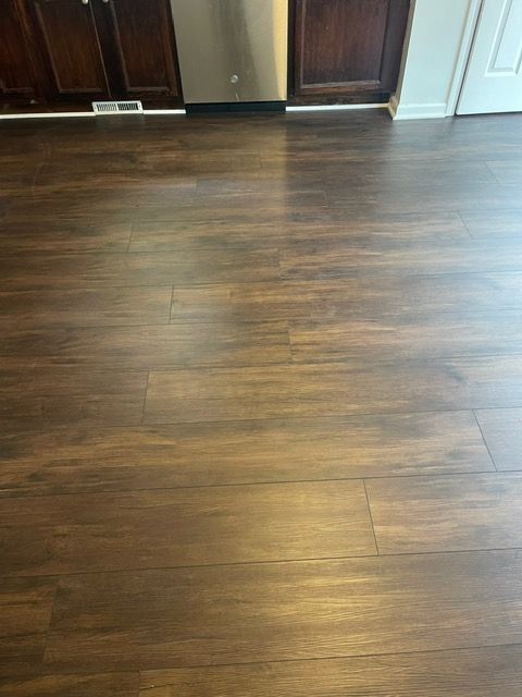 A kitchen with a wooden floor and a stainless steel dishwasher.