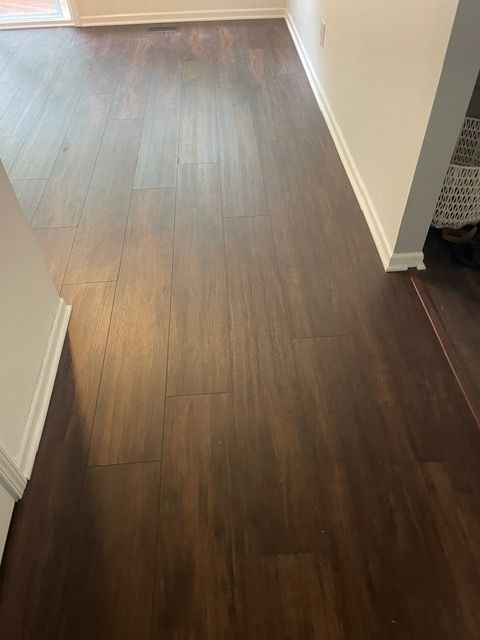 A hallway with a wooden floor and white walls.