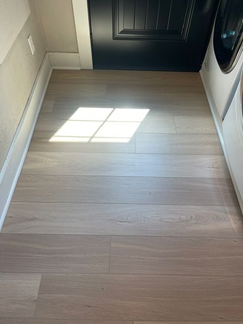 A laundry room with hardwood floors and a washer and dryer.