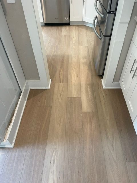 A kitchen with hardwood floors and stainless steel appliances.