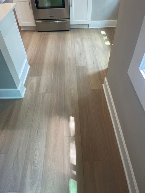 A kitchen with hardwood floors and a stainless steel stove.