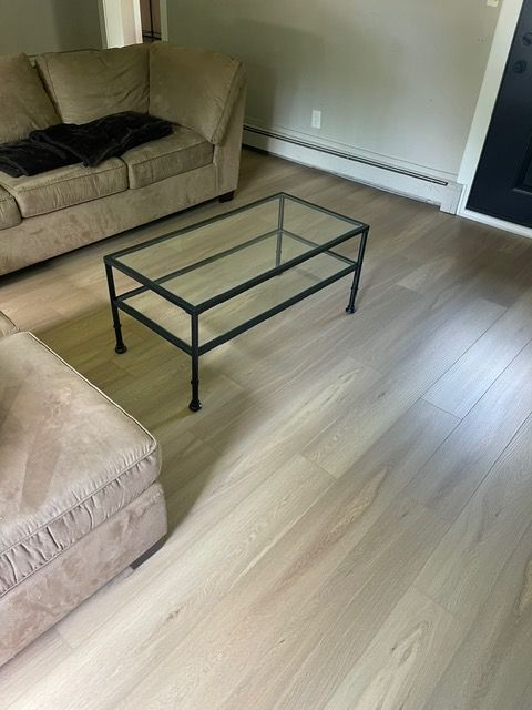 A living room with a glass coffee table and a couch.
