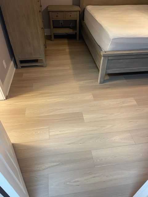 A bedroom with a bed , nightstand and dresser.