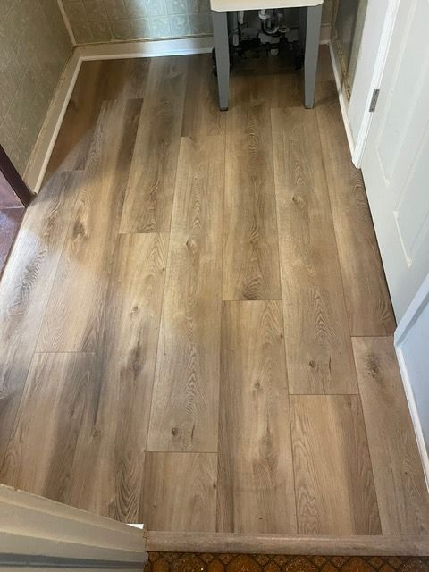 A room with a wooden floor and a table in it.