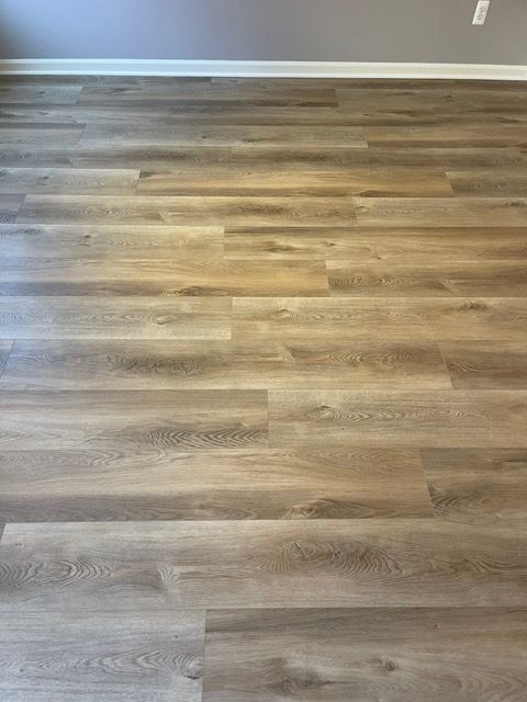 A room with a wooden floor and a gray wall.