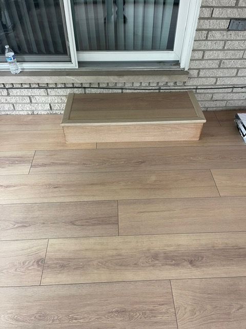 A wooden box is sitting on a wooden floor next to a window.