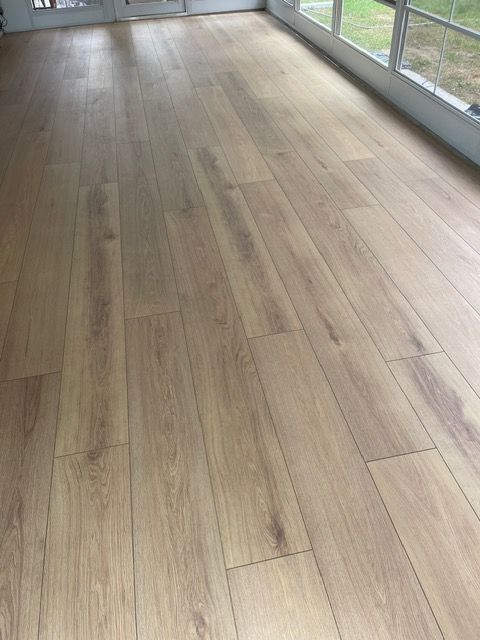 A room with a wooden floor and a lot of windows.