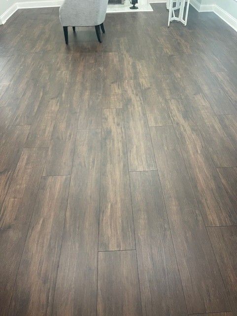 A living room with a wooden floor and a chair.