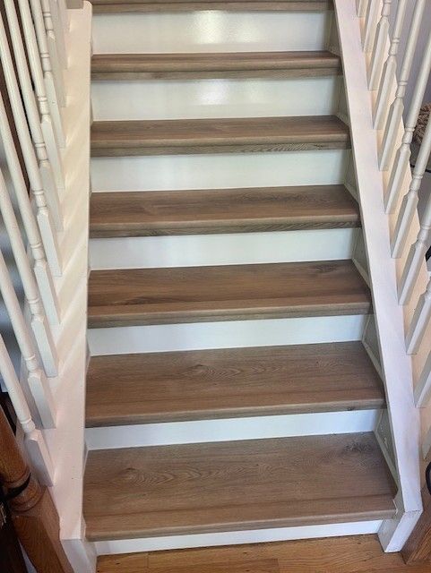 A wooden staircase with white railings and wooden steps.