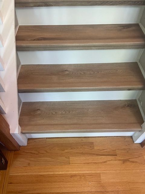 A close up of a wooden staircase with a wooden floor.