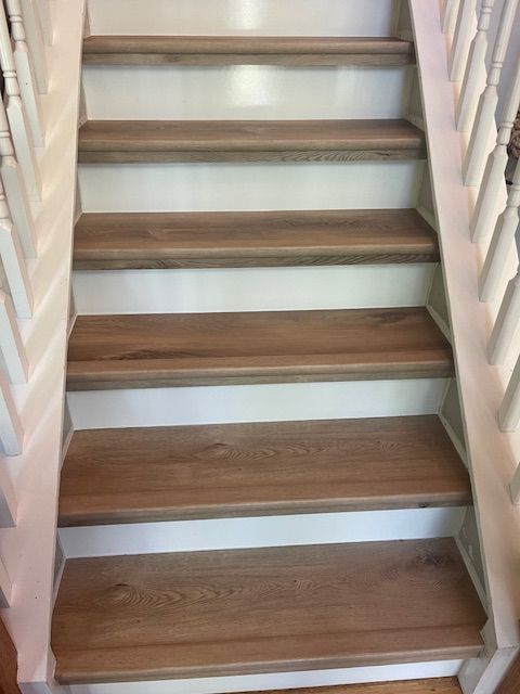 A set of stairs with wooden steps and white railings.