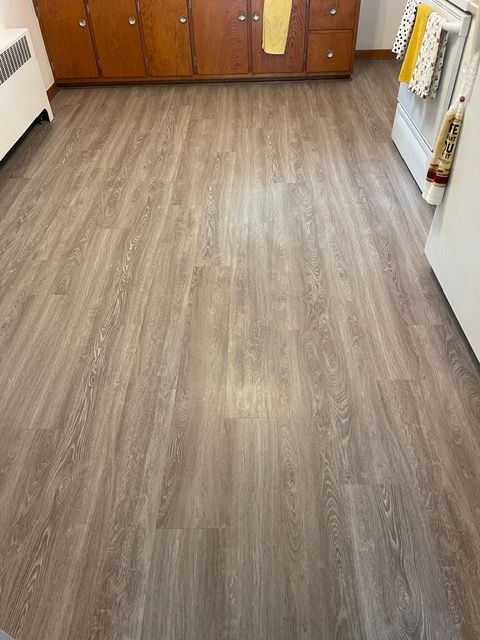A kitchen with hardwood floors and wooden cabinets.