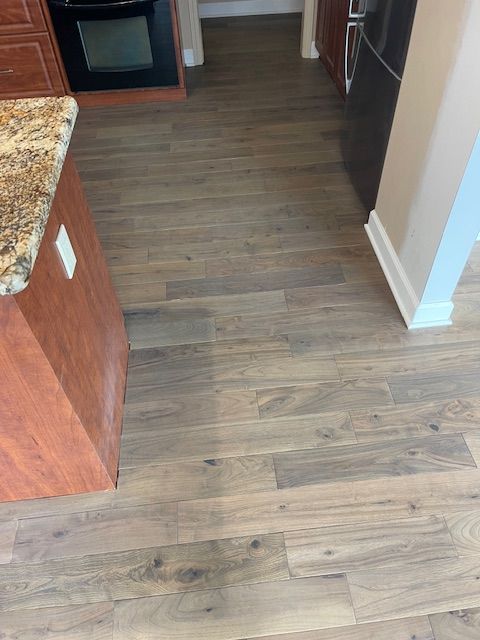 A kitchen with hardwood floors and a granite counter top.
