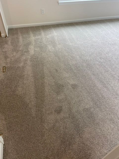 A living room with a large carpeted floor and a window.