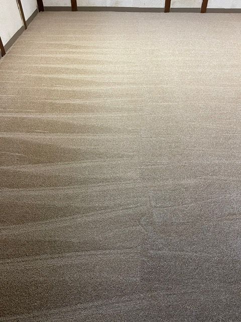 A large room with a carpeted floor and a wooden wall.