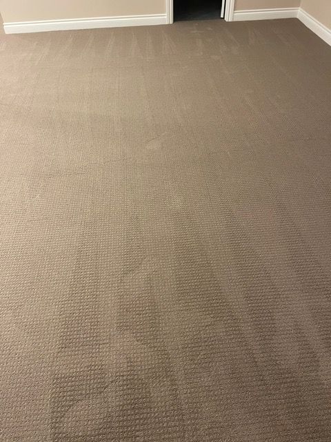 A room with a carpeted floor and a door.