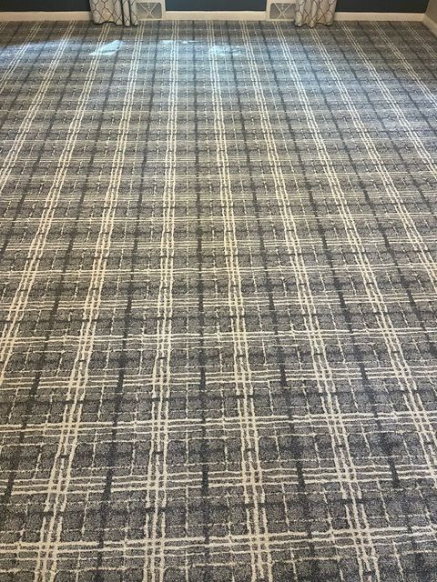 A close up of a plaid carpet in a room.