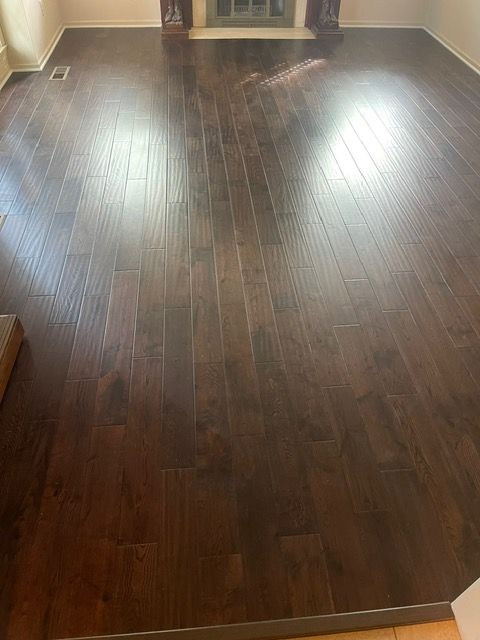 A living room with hardwood floors and a fireplace.