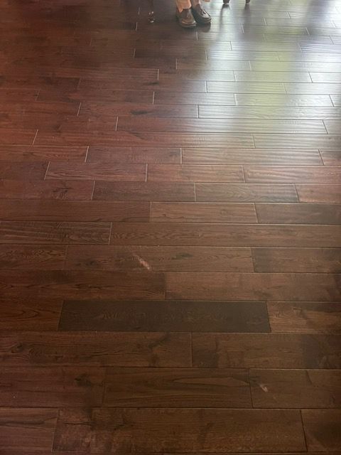 A person is standing on a wooden floor in a room.