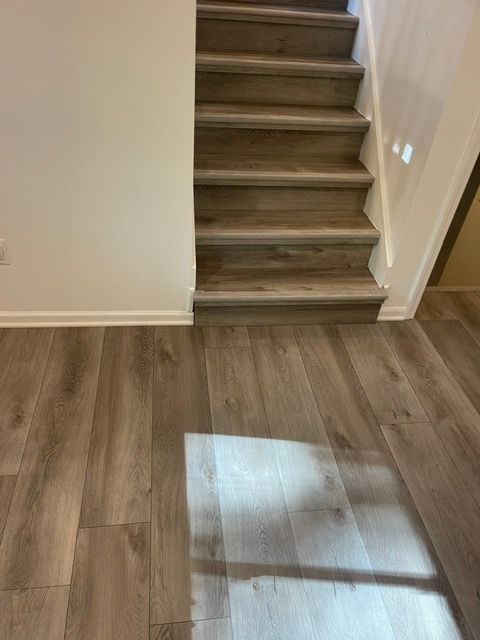 The stairs are made of wood and there is a shadow on the floor.