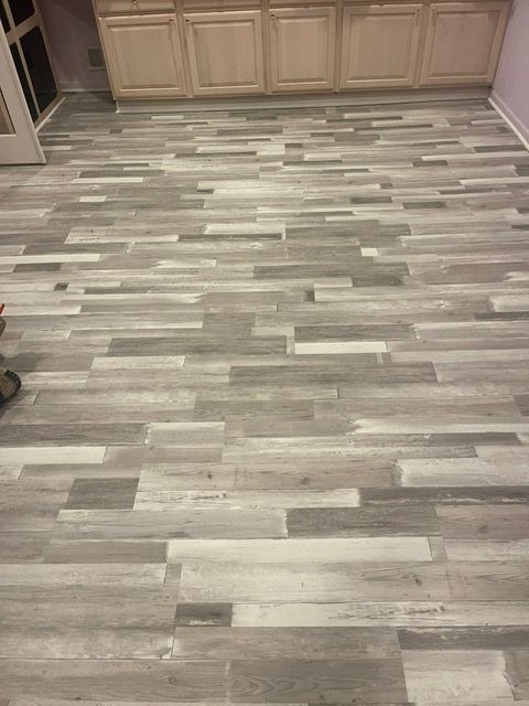 A kitchen with a wooden floor and white cabinets.