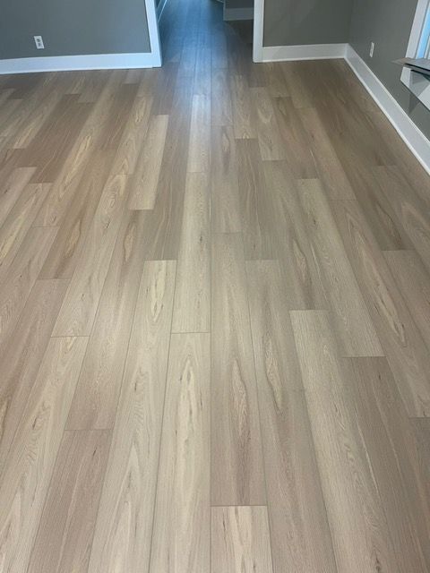 A living room with a wooden floor and a hallway.