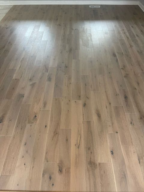 A living room with a wooden floor and a rug.
