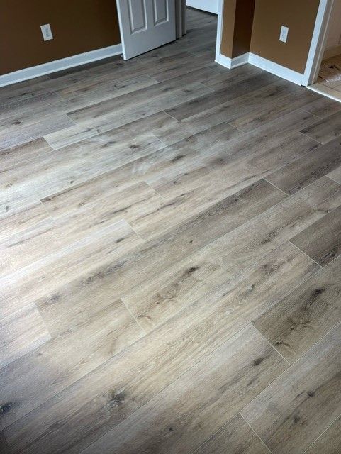A room with a wooden floor and brown walls.