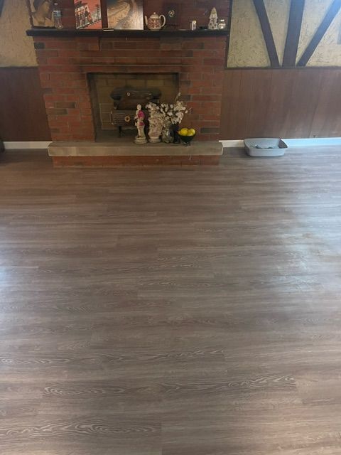 A living room with a fireplace and a wooden floor.