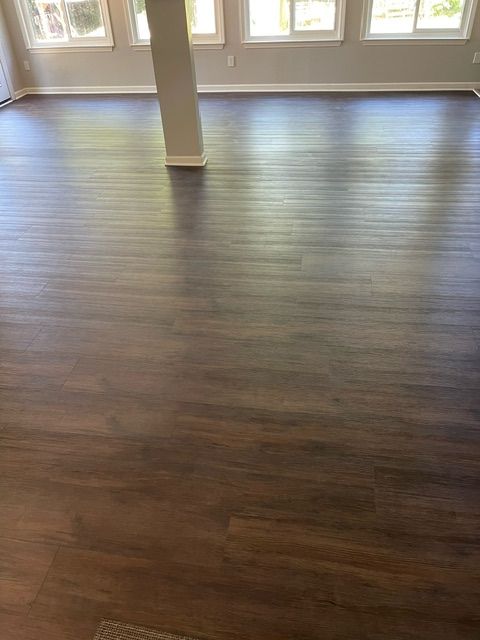 A living room with a wooden floor and a pillar.