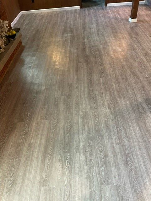 A living room with a wooden floor and a fireplace.