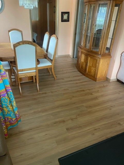 A dining room with a table and chairs and a hutch.