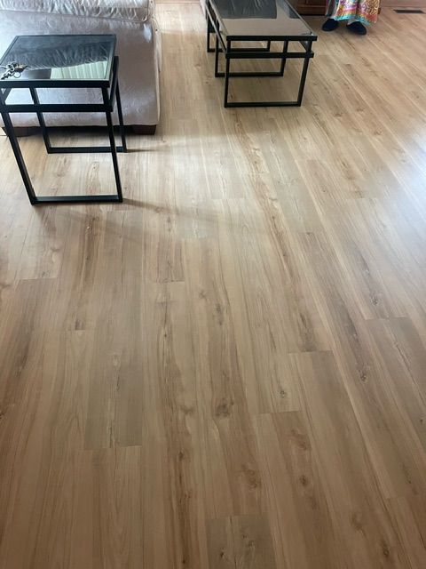 A living room with a wooden floor and two coffee tables.