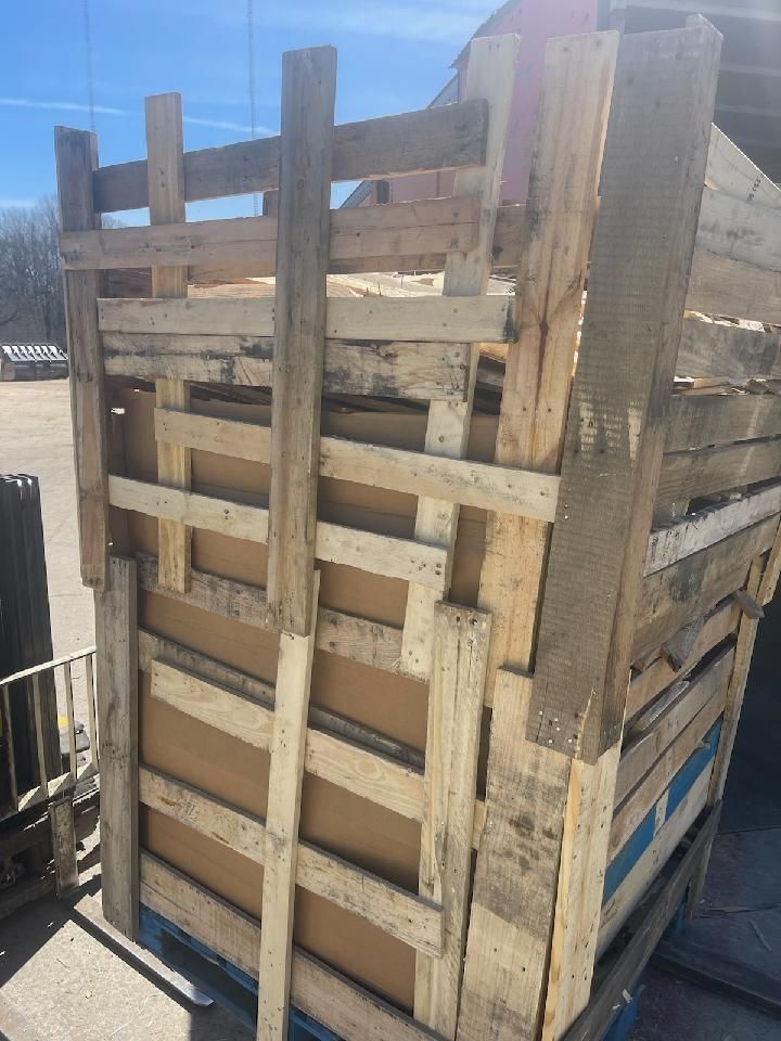 A large wooden crate is sitting on top of a pallet.