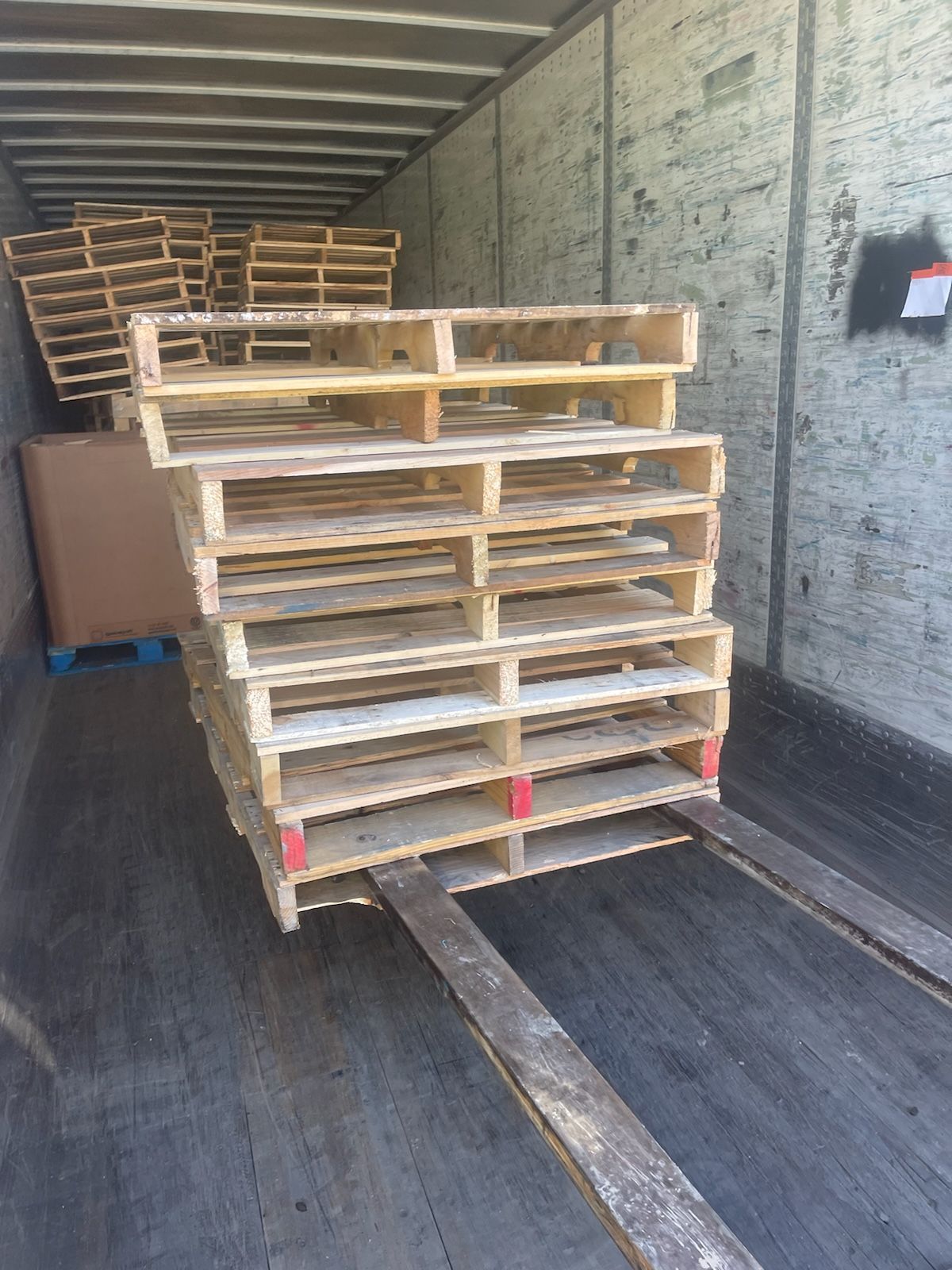 A bunch of wooden pallets are stacked on top of each other in a truck.