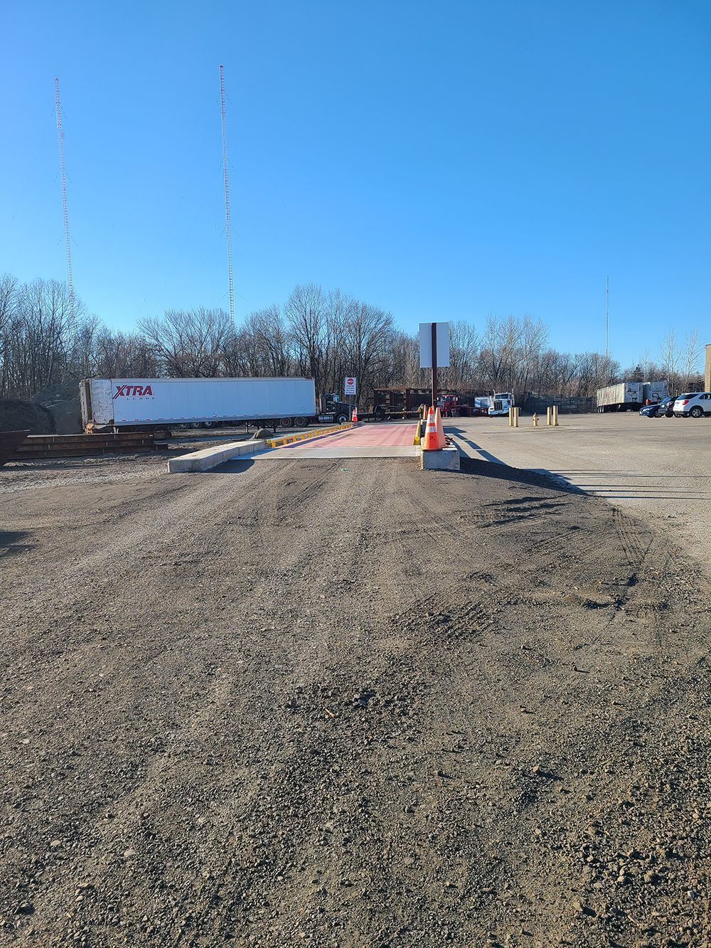 A truck is parked in the middle of a gravel road.