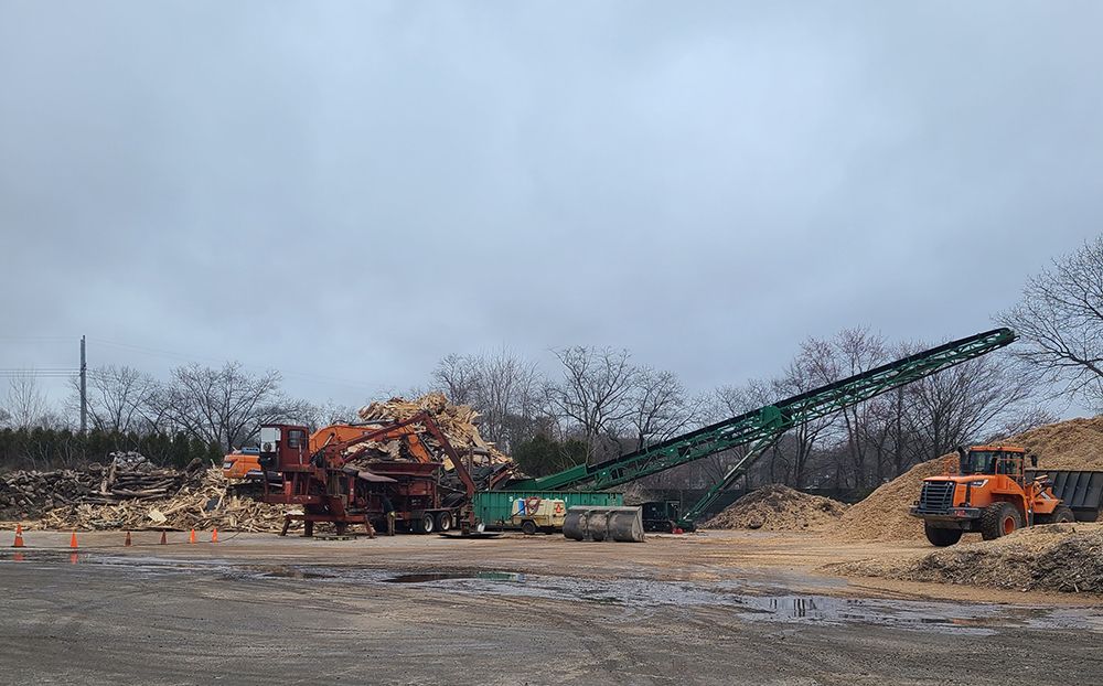 A large pile of wood is being processed in a factory.