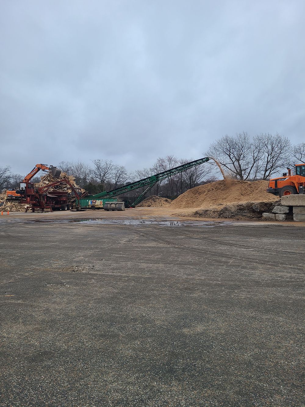 A construction site with a lot of machinery and a pile of wood.