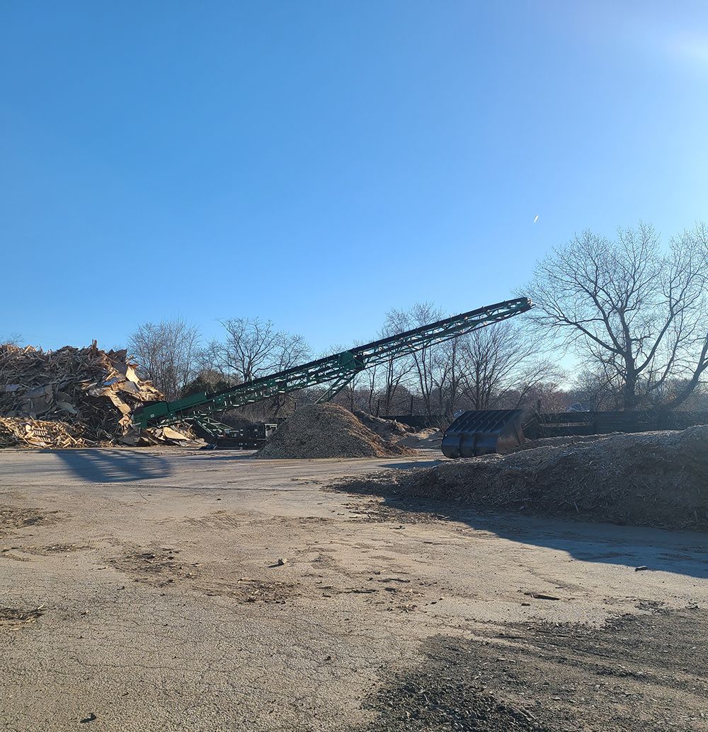 A large conveyor belt is sitting in the middle of a dirt field.