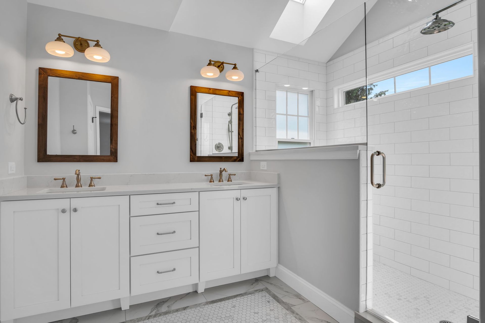 A bathroom with two sinks and a walk in shower.