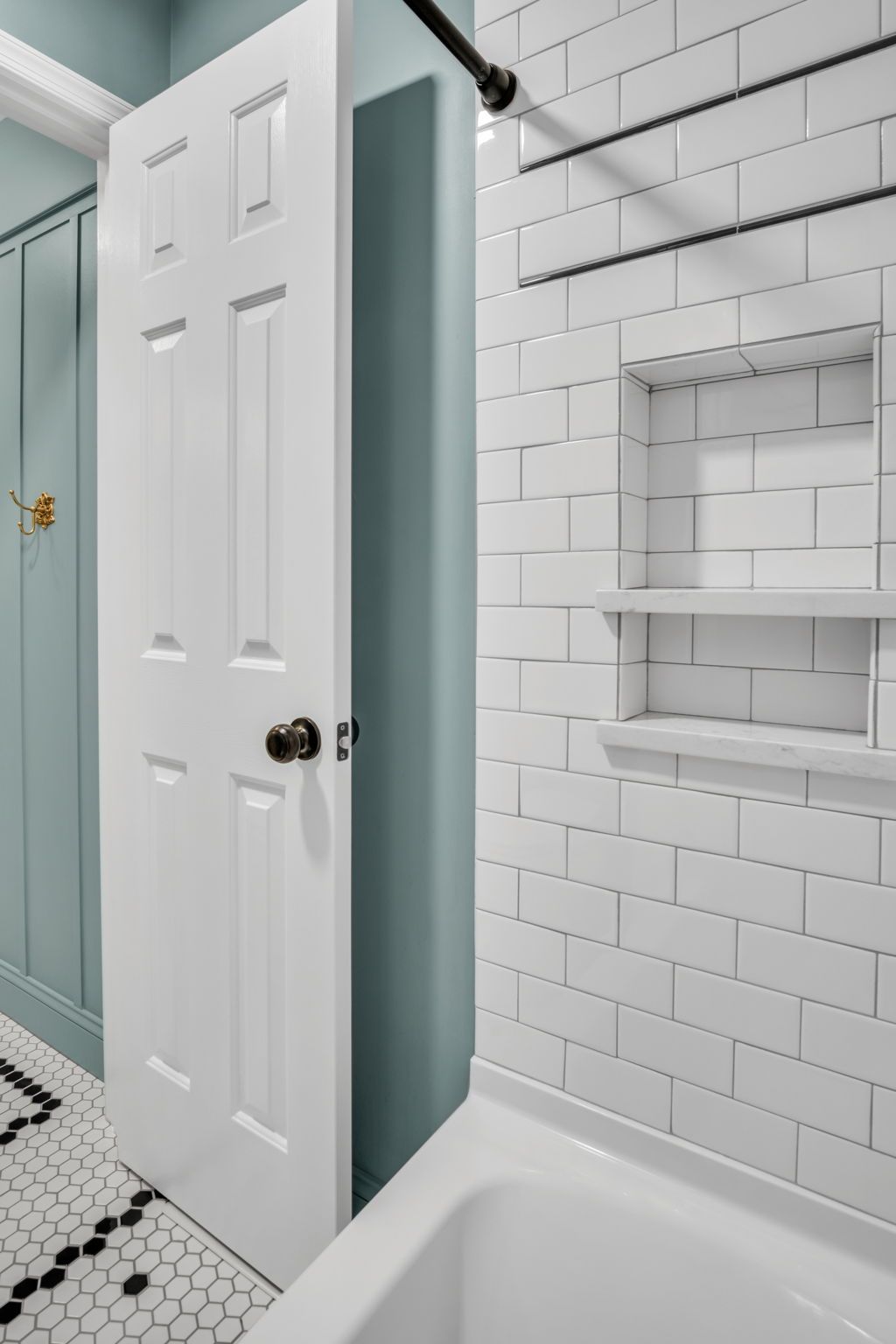 A bathroom with white subway tiles and a bathtub.
