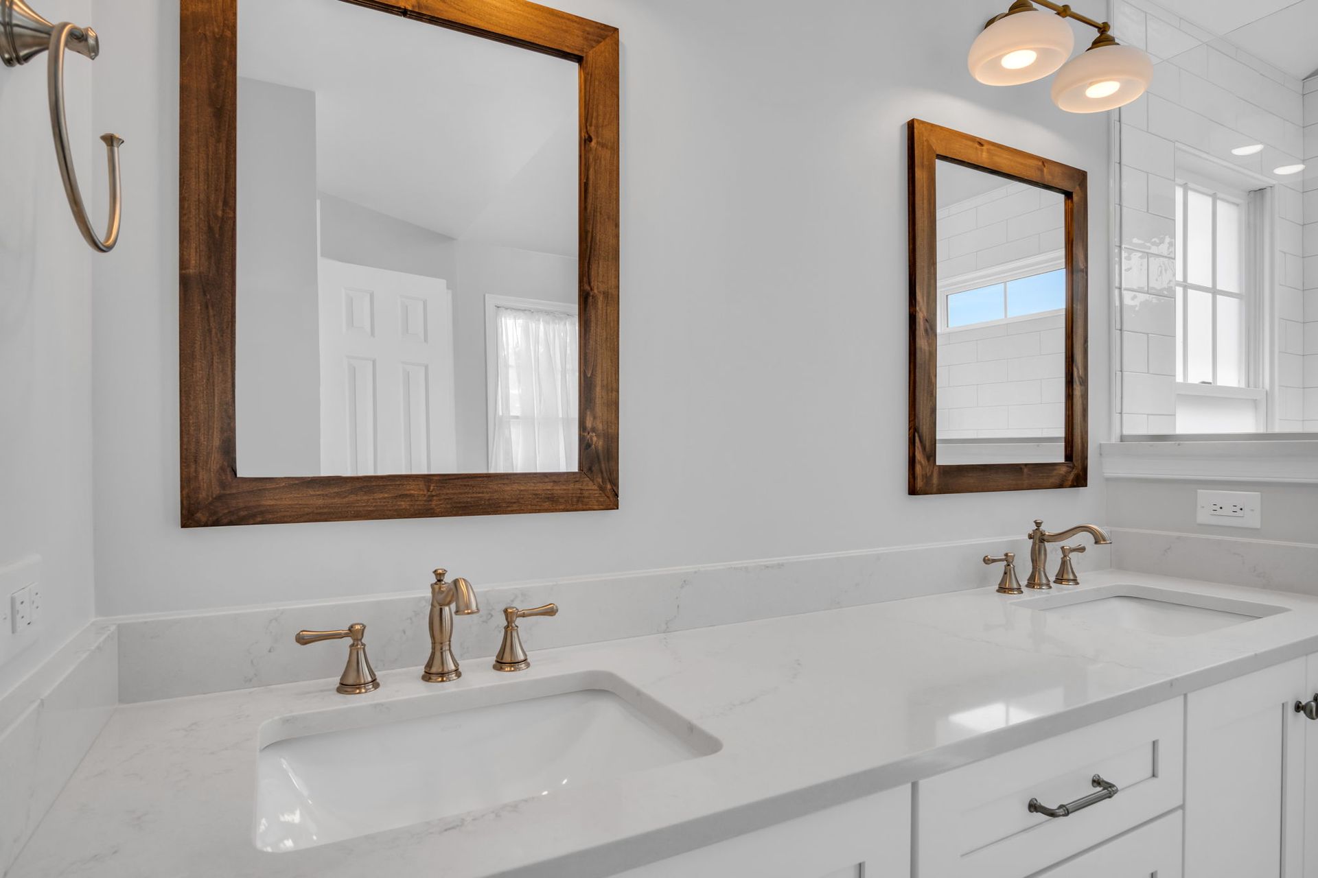 A bathroom with two sinks and two mirrors on the wall.