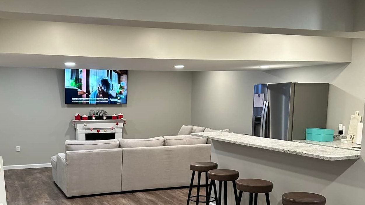 A living room with a couch and a television on the wall.
