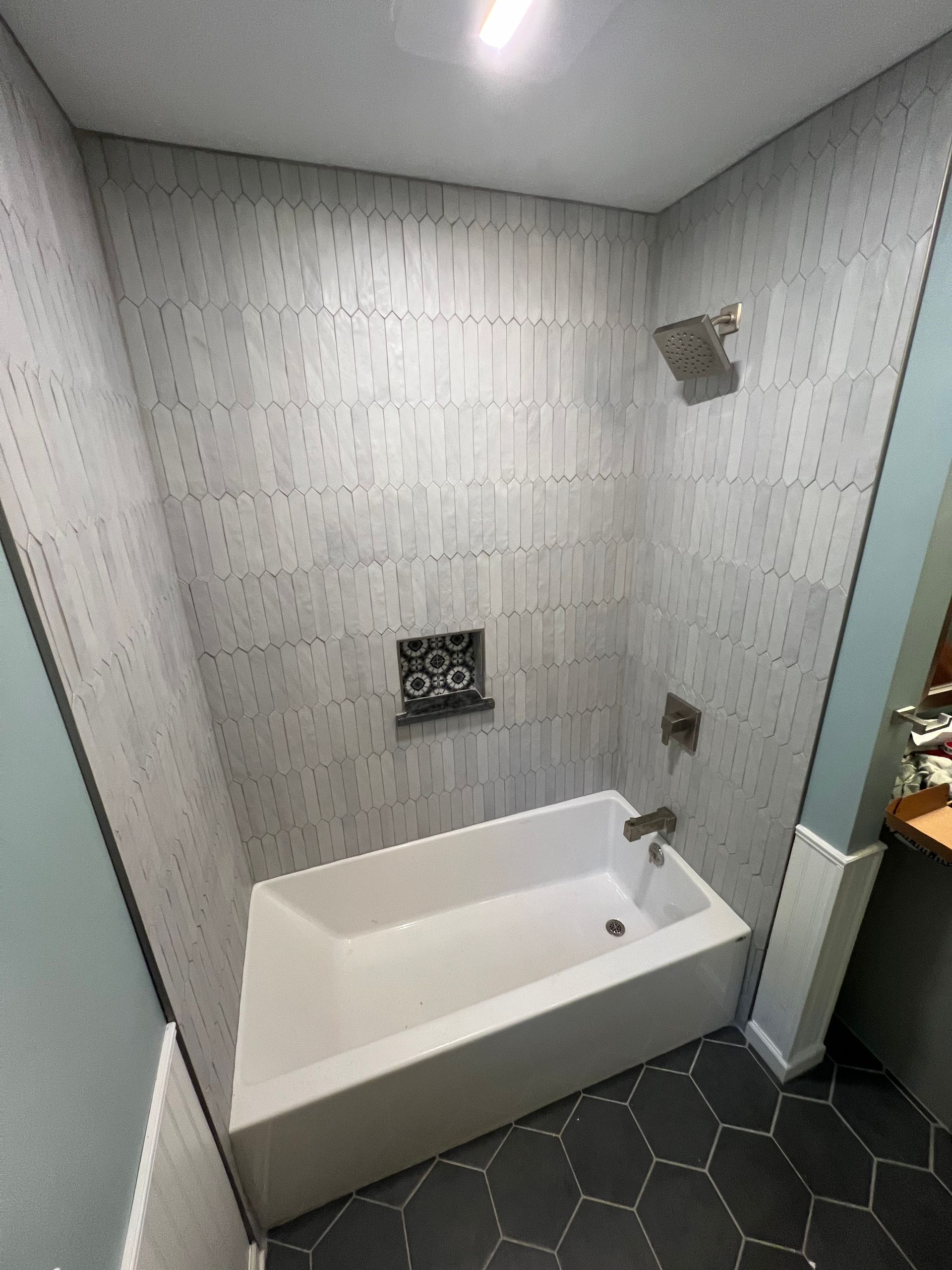 A bathroom with a bathtub and a shower.