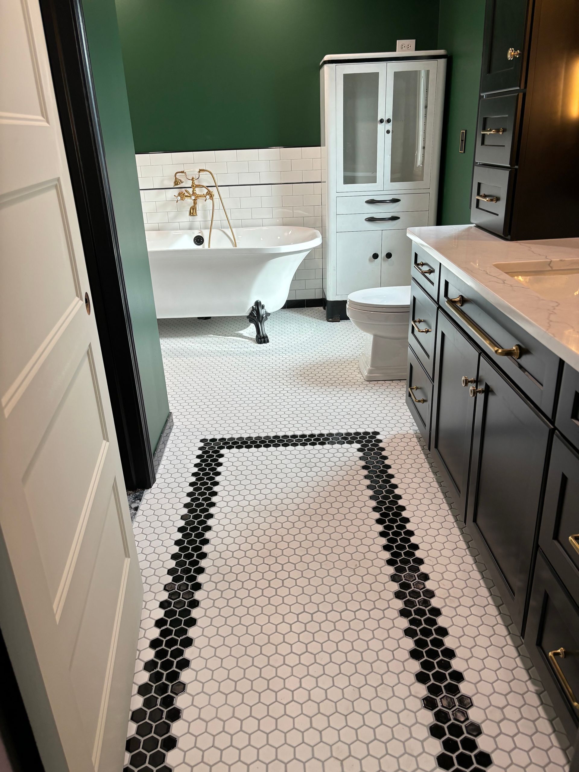 A bathroom with a black and white tile floor