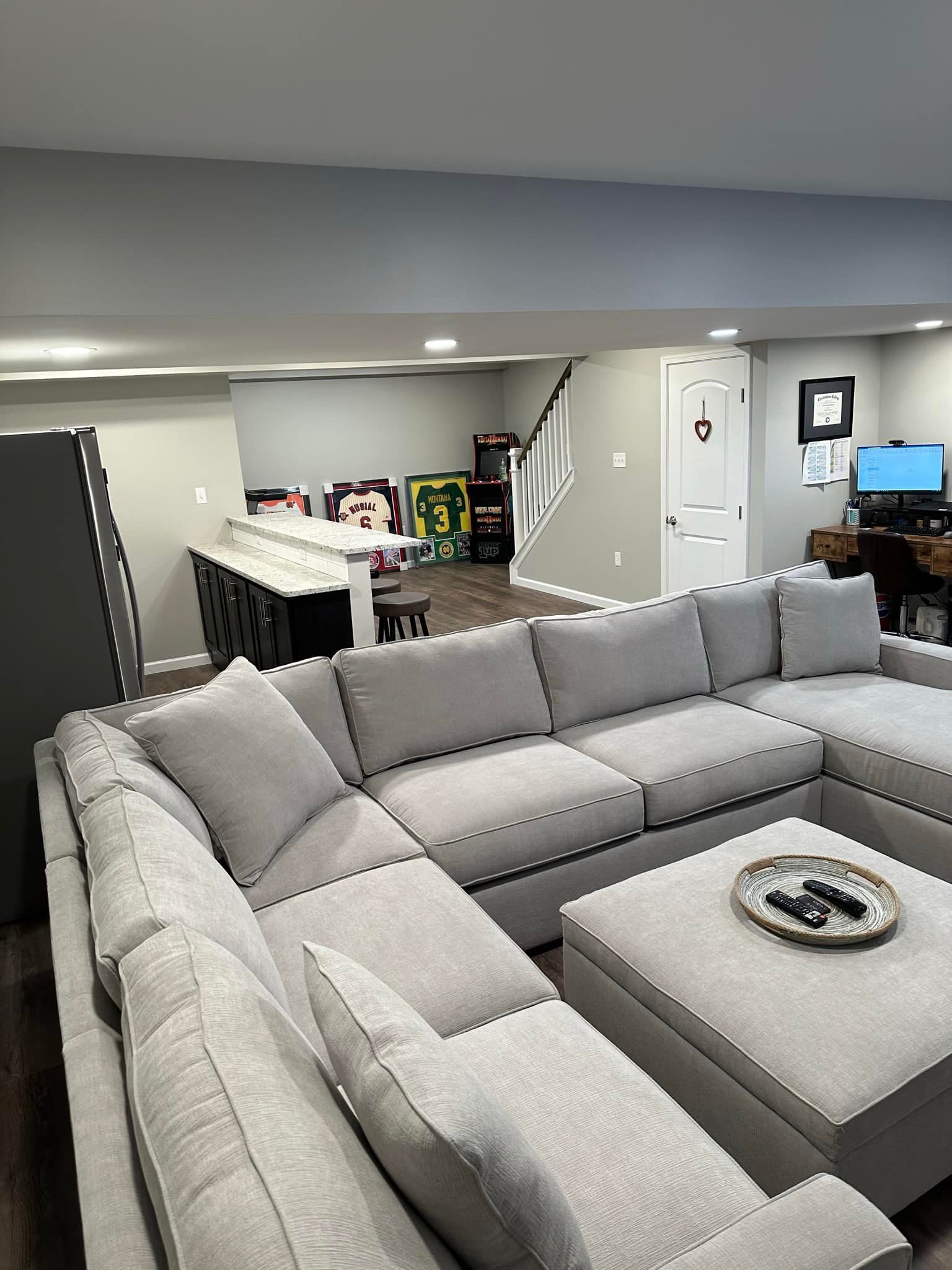 A living room with a large sectional couch and ottoman.